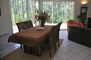A dining area with a table, chairs, and a vase of flowers.
