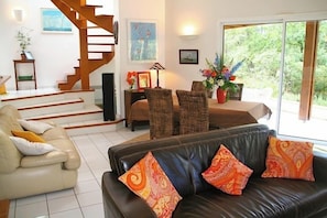 A living room with a sofa, a chair, a coffee table, and a staircase. - Beautiful house with idyllic views G0268 (Lacanau)