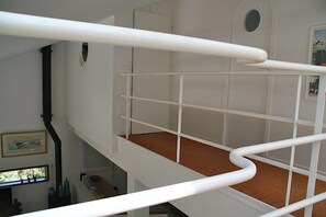 Un escalier blanc avec une rampe menant à un niveau inférieur.