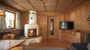 Un intérieur de chalet chaleureux avec une cheminée, des meubles en bois et un téléviseur.