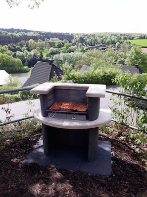 Enjoy al fresco dining with a view of the serene river and forested hill.