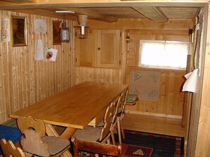 Cozy dining area with a long table and six chairs, offering a view of the outside.