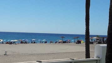 A beach with umbrellas and people.