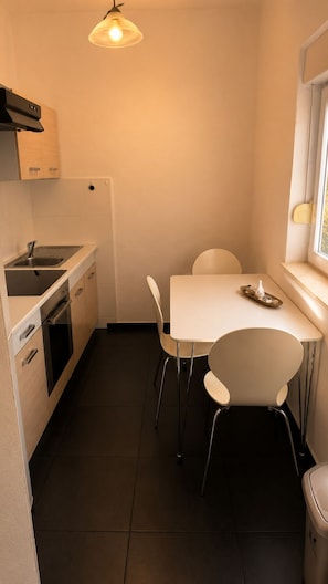 Cocina compacta con comedor, ventana y pileta.