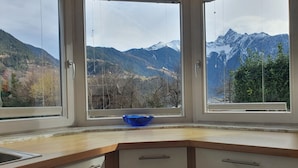 Une cuisine avec vue sur les montagnes, grâce à de grandes fenêtres.