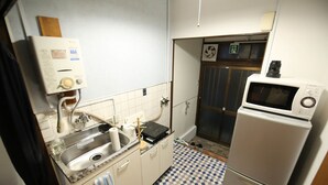 Una cucina funzionale con lavandino, forno a microonde e scaldabagno.
