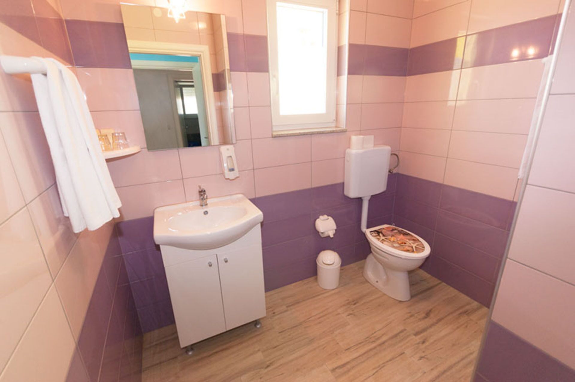 A bathroom with a sink, toilet, and mirror.