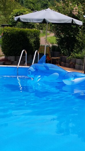 A swimming pool with a blue inflatable shark float. - Vacation in Saxon Switzerland Garden Pool Stove Sauna (Sebnitz)
