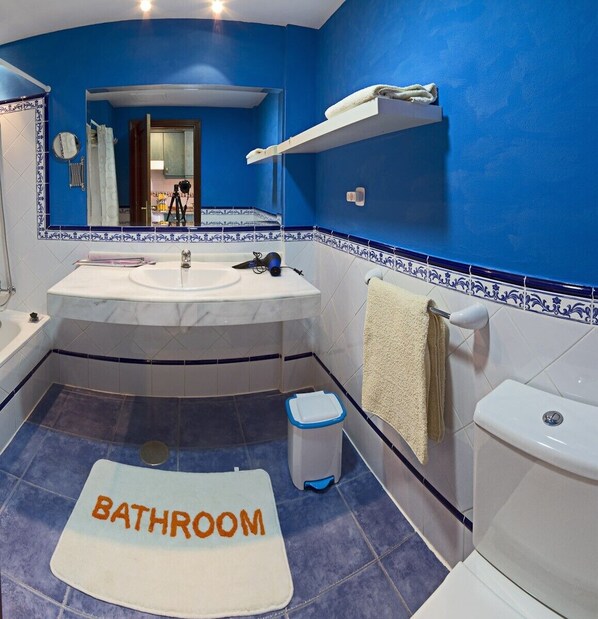 A bathroom with a blue wall, white sink, and a "BATHROOM" mat on the floor. - Feel-good oasis for 4 people in excellent location (Corralejo)