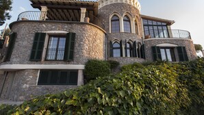 Un bâtiment en pierre doté d’un balcon, de fenêtres en arc de cercle et d’une façade incurvée.