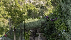 Un escalier en pierre menant au sommet d’une colline, avec une maison en arrière-plan.