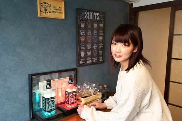 A person standing at a bar with a framed menu and a sign above it.