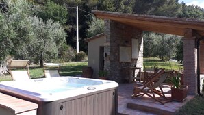 A hot tub in a stone-walled outdoor area with wooden furniture and olive trees in the background. - beautiful accommodation in a quiet location and with a huge garden, M2 (Pomaia)