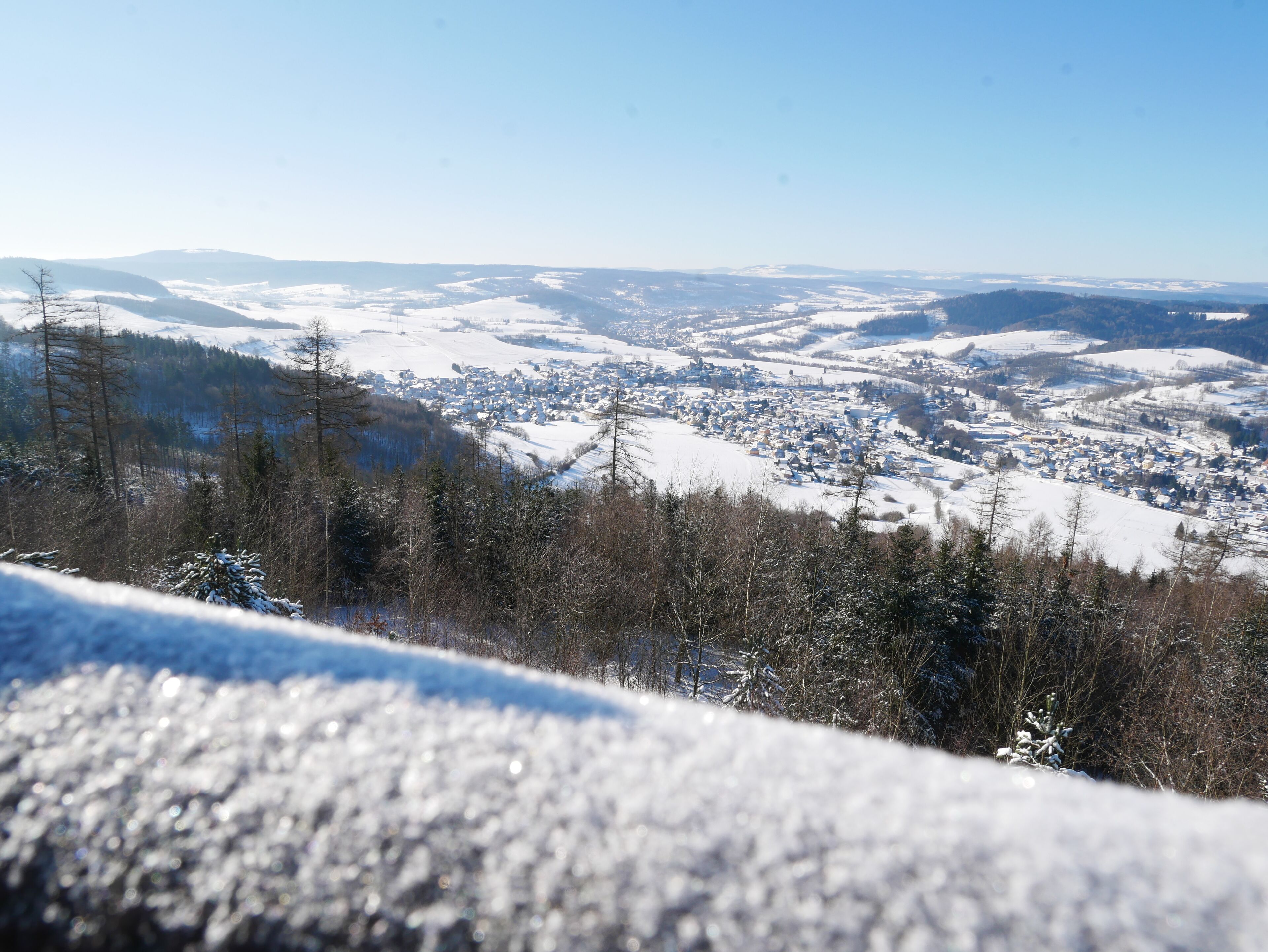 Un paysage enneigé avec une ville située dans la vallée en contrebas.