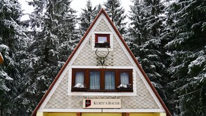 A yellow building with a triangular roof and a sign reading "Kurti's Baude". - Holidayflat with balcony, seperate entrance, near Thuringian Forest (Floh- Seligenthal)