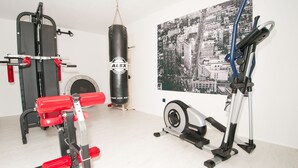 Un gimnasio en casa con una bicicleta estática, un saco de boxeo y equipo de levantamiento de pesas.