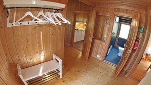 A wooden interior with a bench, a drying rack, and a bathroom visible through an open door. - BEAUTYFULL COTTAGE WITH MOTORBOAT and CANOE (Säffle)
