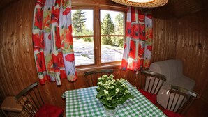 A wooden cabin interior with a checkered table, chairs, and a window with curtains. - BEAUTYFULL COTTAGE WITH MOTORBOAT and CANOE (Säffle)