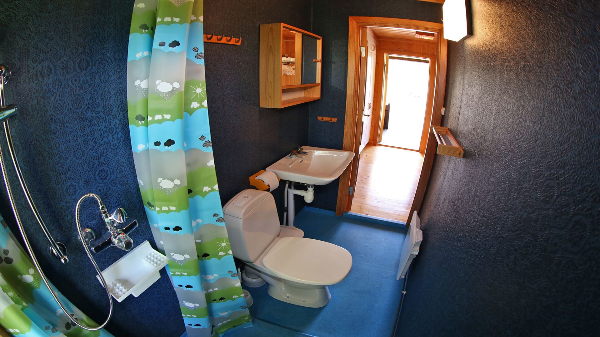 A small bathroom with a toilet, sink, and shower.
