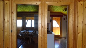 A wooden interior with a dining area, kitchen, and a small island. - Farm holidays Rotsteinhof (Vöran)
