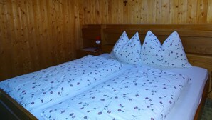 A wooden room with a bed, a nightstand, and a skylight. - Farm holidays Rotsteinhof (Vöran)