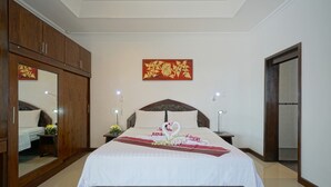 A hotel room with a large bed, wooden wardrobe, and a decorative wall hanging. - Luxurious, quiet, private Pool-Villa Lotus, 7/7 housekeeper/butler (Phuket)
