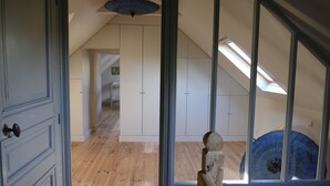 An interior view of a room with wooden flooring, white cabinets, and a skylight. - Exclusively renovated farmhouse in southern Brittany (Fouesnant)