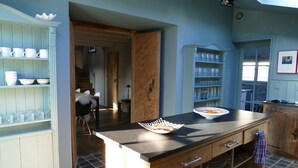 A kitchen with a wooden countertop, a sink, and a window. - Exclusively renovated farmhouse in southern Brittany (Fouesnant)