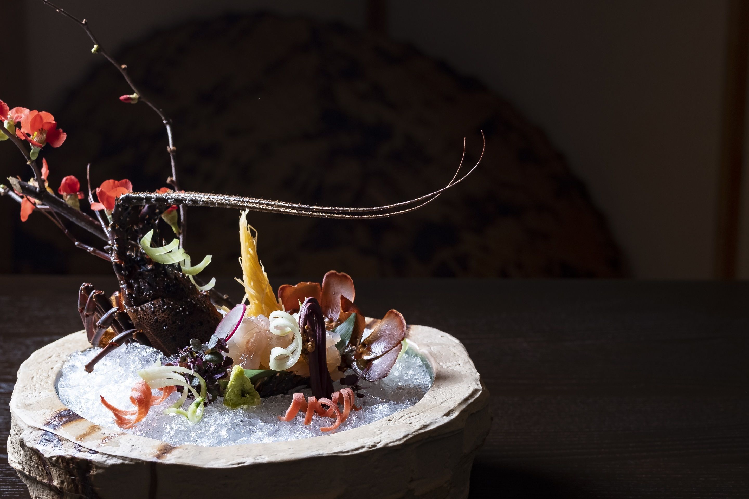 A lobster dish on a rustic wooden table.