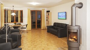 Ein Wohnzimmer mit Kamin, Sofas, einem Couchtisch und einem Essbereich mit Stühlen und einem Tisch.