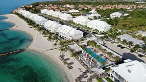 A resort with beachfront villas, a swimming pool, and a beach.