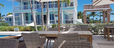 Un resort con asientos al aire libre, una piscina y un edificio con un letrero que dice 'Restaurant & Clubhouse'.