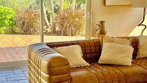 A leather sofa with cushions, a vase, and a painting on the wall. - Villa with pool and view in Luz/Lagos (Luz)