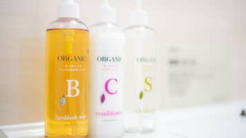 Three bottles of organic personal care products on a white surface.