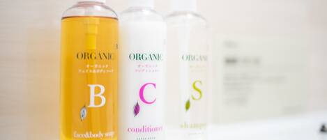 Three bottles of organic personal care products on a white surface.