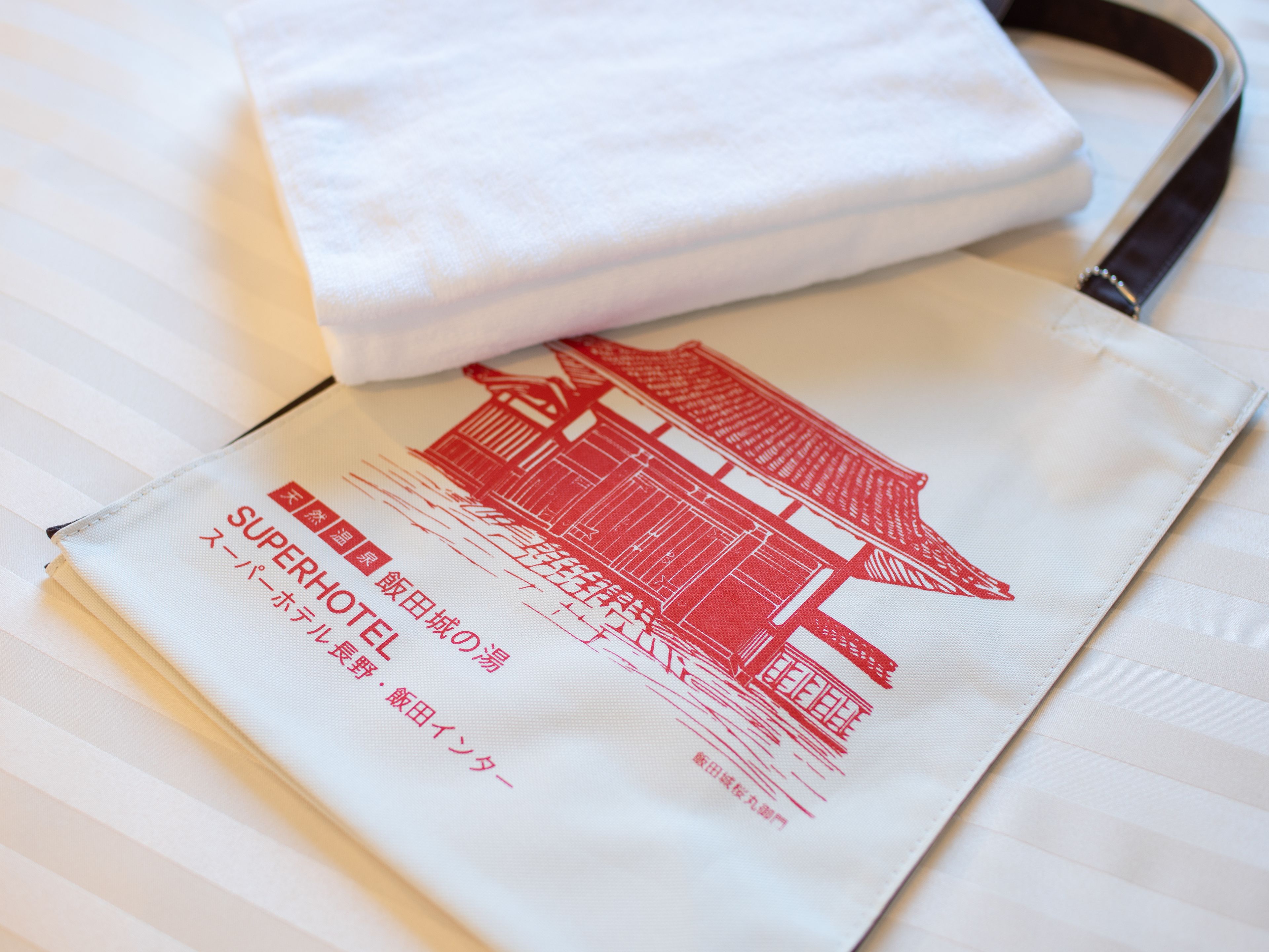Un folleto de hotel con una ilustración de un edificio en rojo y texto en japonés.