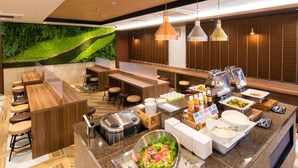 A modern restaurant with a buffet setup, wooden furniture, and a green wall. - Super Hotel Nagano Iida Inter (Iida)