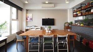 Una cocina moderna con una mesa de comedor de madera, sillas, un televisor de pantalla plana y un salpicadero de ladrillo.