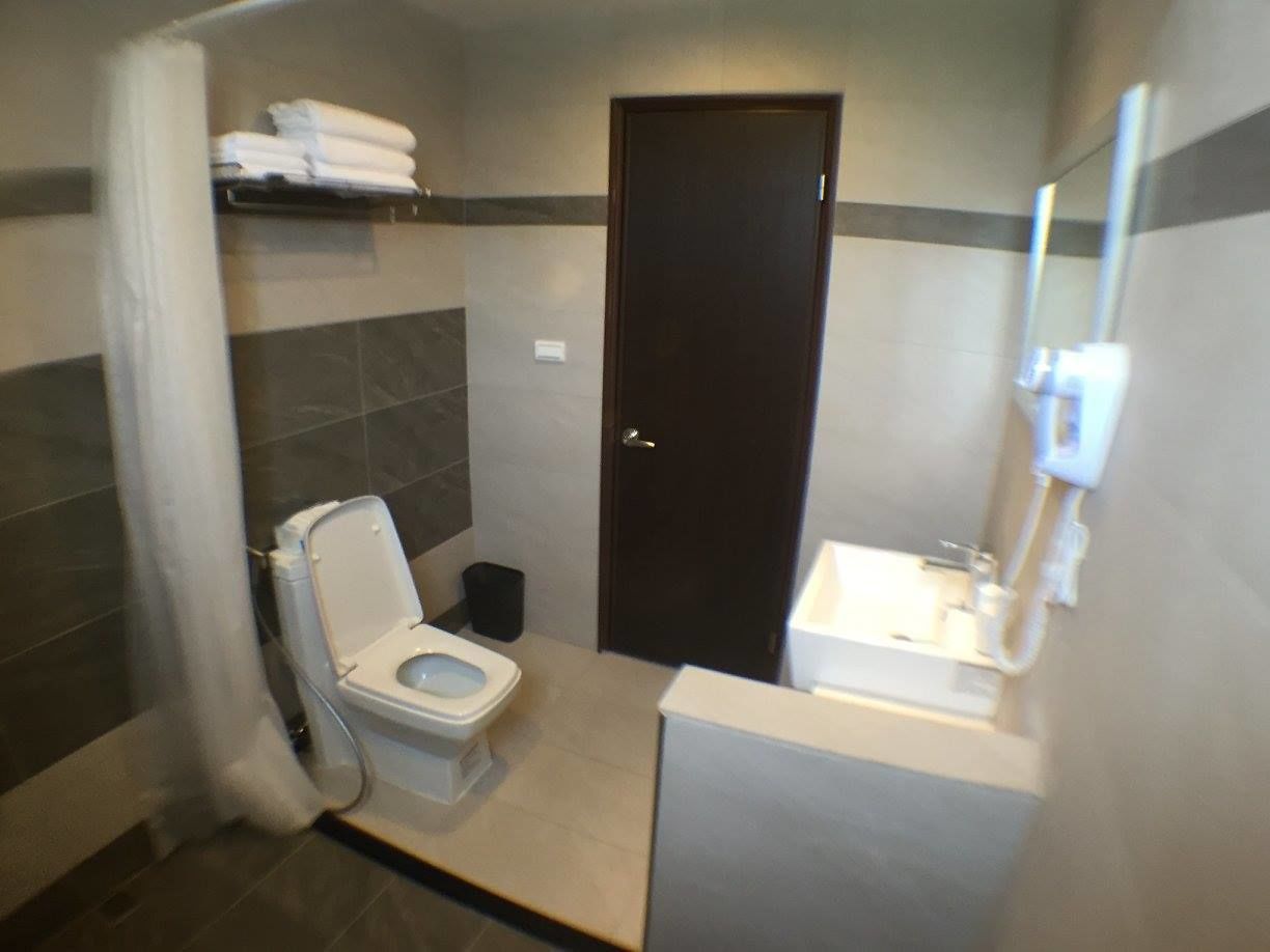 A small bathroom with a toilet, sink, and a door.