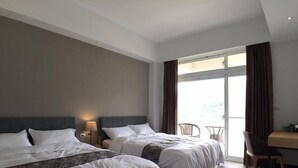 Habitación de hotel con dos camas, un escritorio y una silla.