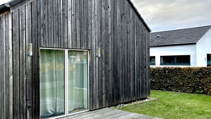 A modern building with a large glass door and a wooden exterior.
