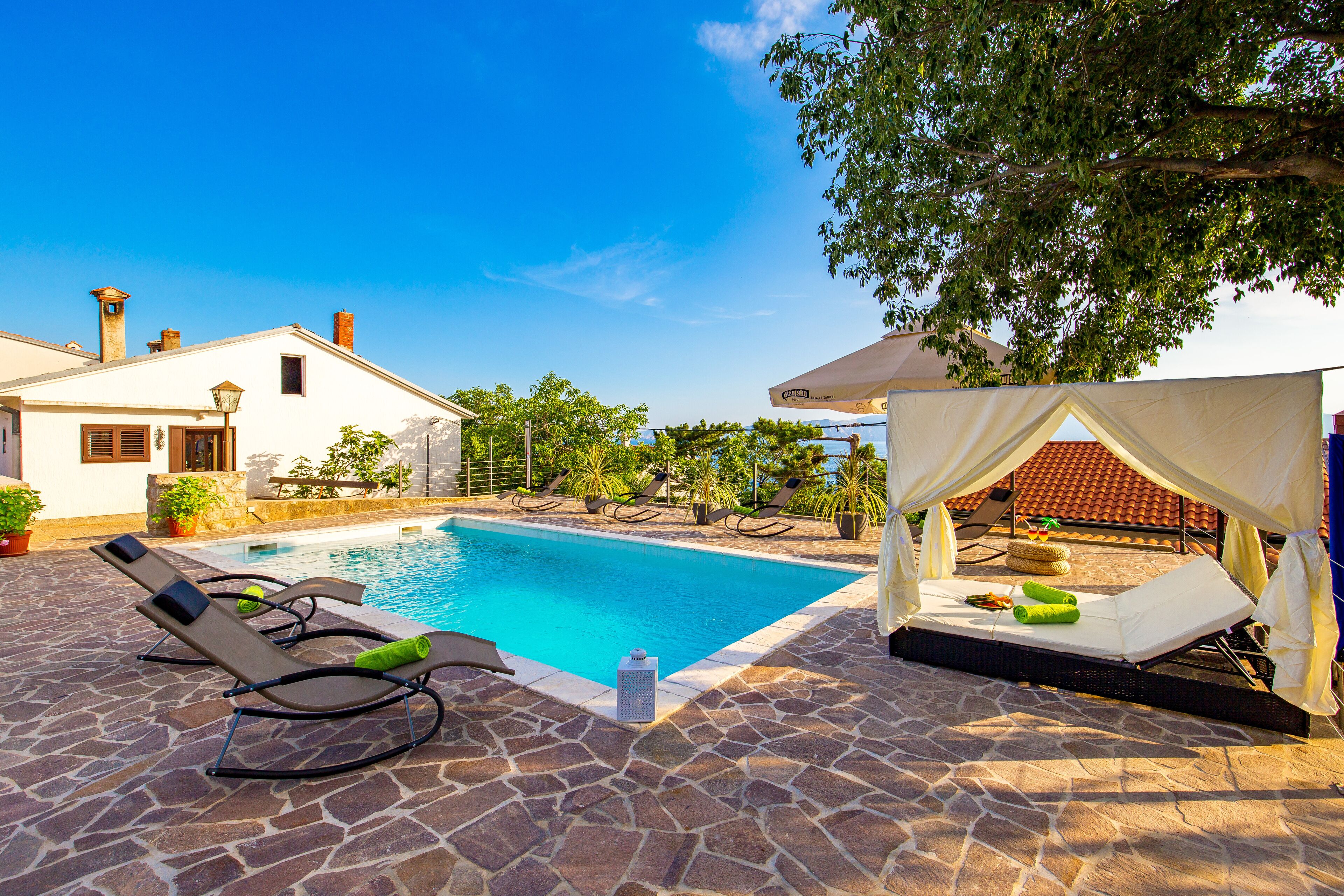 A swimming pool with lounge chairs and a canopy.