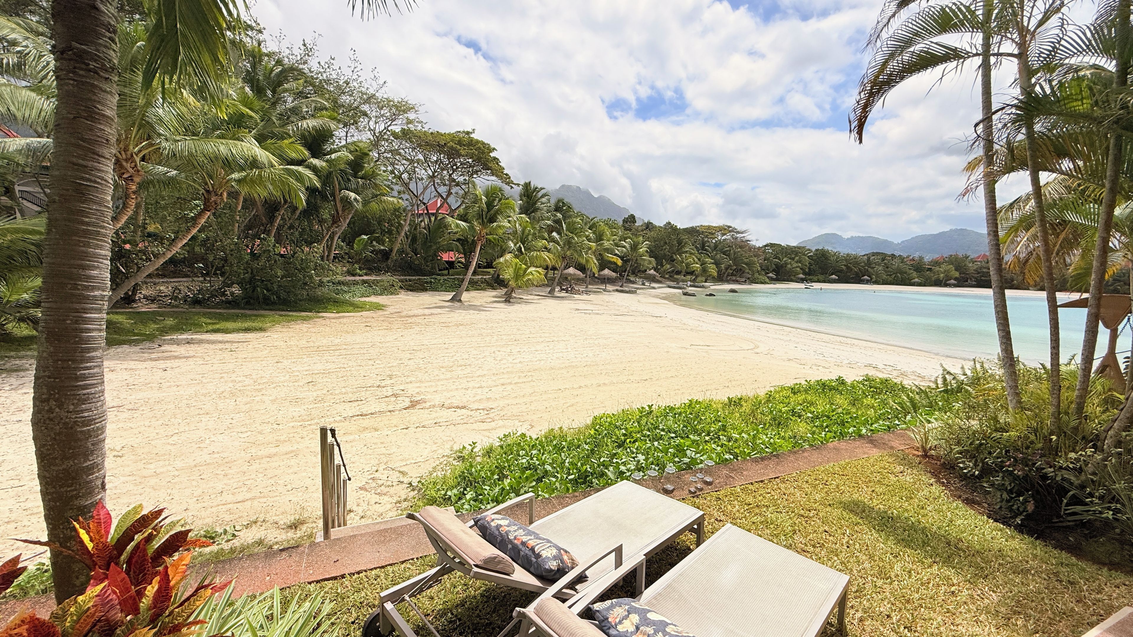 A beach with lounge chairs and a view of the ocean.