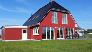 A red house with a large window and a chimney.