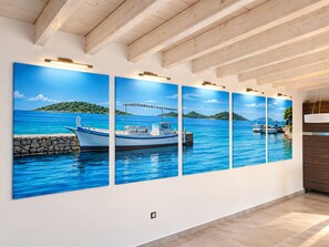Habitación con un gran mural en la pared que muestra un barco en el agua, una pared de piedra y un techo de madera.