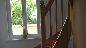 En trätrappa med röda, matbeklädda trappsteg som leder upp till en liten plattform.