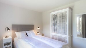 A neatly arranged bedroom with a large bed, bedside tables, and a wardrobe. - Apartment 3 - Edersee time out (Edertal)