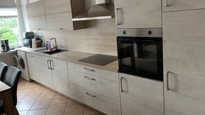 A modern kitchen with a built-in oven, a coffee maker, and a washing machine.