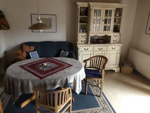 Enjoy a romantic dinner for two at this beautifully set dining area with a round table, tablecloth, and central candle holder.