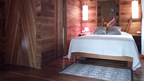 Ein Schlafzimmer im Holzblockhaus-Stil mit einem Bett, einem Nachttisch und einem dekorativen Wandbild.